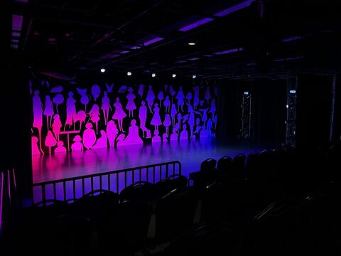 Off Broadway Theater Stage showing colorful lighting and a whimsical backdrop